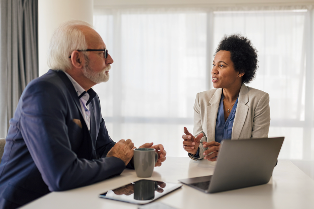 Female leadership coach mentoring older buisness man